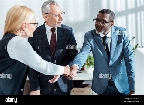 Selective Focus Of Businessman In Glasses Looking At Handsome African American Man Shaking Hands