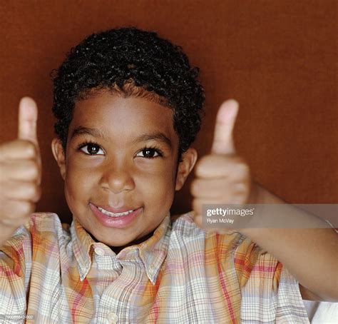 Boy Smiling And Giving Thumbs Up Signal Portrait High Res Stock Photo