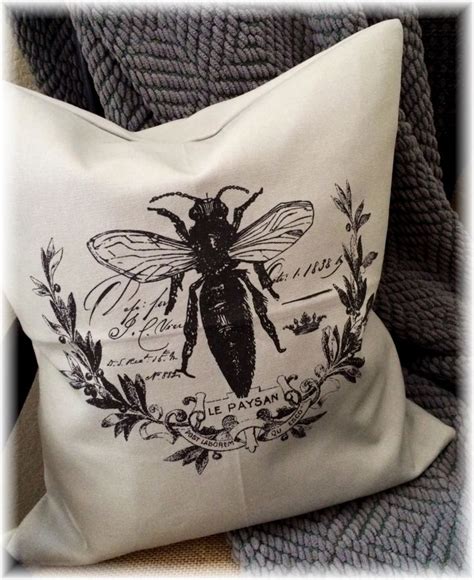 A Black And White Pillow With A Bee On It