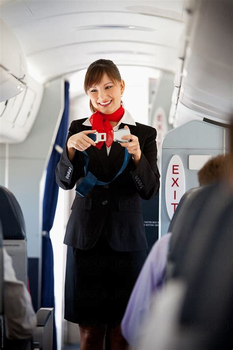 Airplane Stewardess Demonstrates Seat Belt By Stocksy Contributor