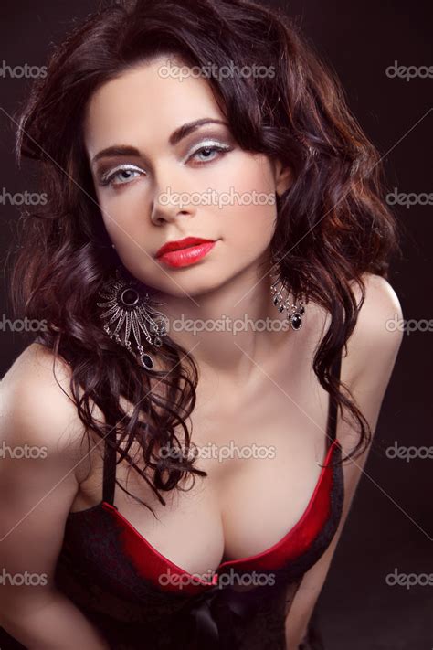 Menina bonita e sexy vestindo lingerie vermelha sobre o escuro Atrações Fotografias de Stock
