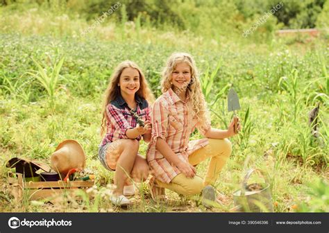 Sisters Together Helping At Farm Girls Planting Plants Garden And