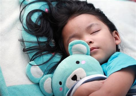 süße kleine asiatische mädchen schlafen und umarmen teddybär premium foto