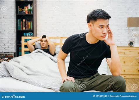 Asian Gay Couple Having Argument With Each Other In Bedroom Thoughtful