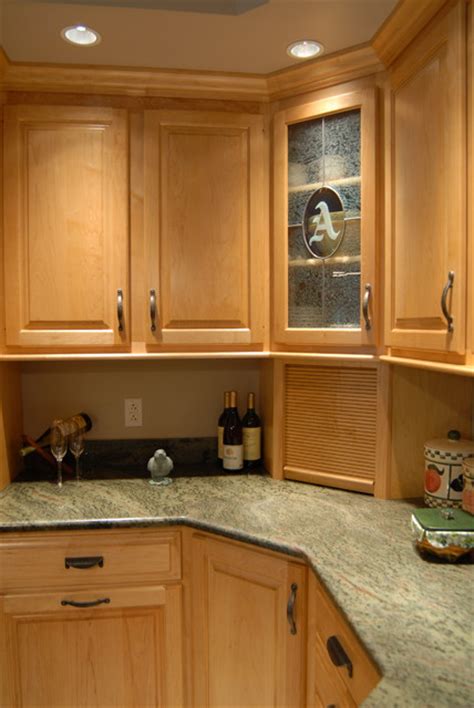 Gray granite tops are finished to a high gloss. Custom Maple kitchen cabinets in a Honey Spice finish ...