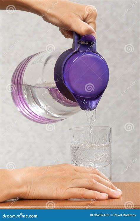 Hands Pouring Water Into A Glass From A Jug Stock Image Image Of