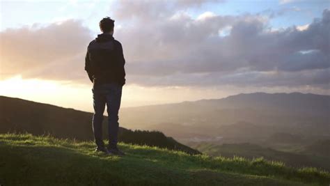 Back View Of Young Man Looking At Sun In Nature Mountain Outdoor At