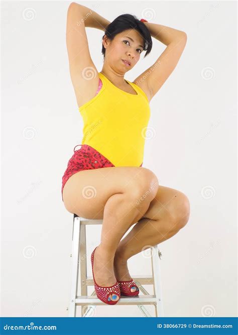 Sexy Aziatische Vrouwelijke Zitting Op De Bovenkant Van Een Ladder Stock Afbeelding Afbeelding