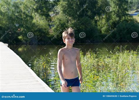 Happy Boy 11 Years Old Goes Swimming On A Wooden Pier On The