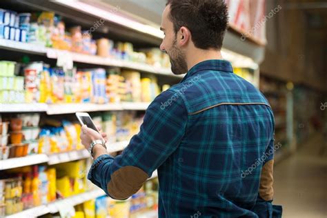 Man Using Mobile Phone While Shopping In Supermarket — Stock Photo