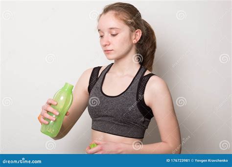 Cute Young Girl With A Fitness Bracelet Drinks Water From A Bottle