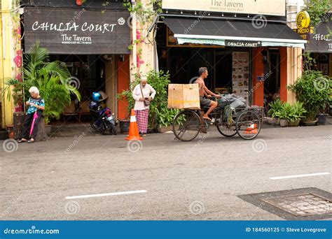 Man With Tanned Leathery Skin Rides A Three Wheeled Cargo Bike