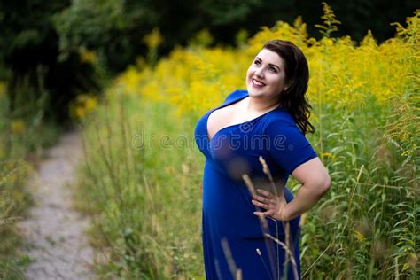 plus size fashion model in blue dress with a deep neckline outdoors beautiful fat woman with