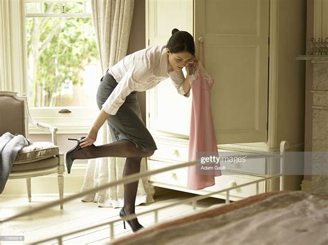Young Woman Getting Dressed Whilst Using Mobile Phone Photo Getty Images