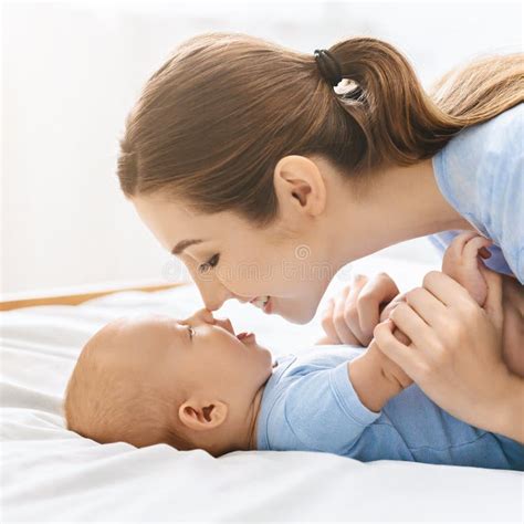 Mother And Baby Touching Noses In Bed Having Fun Together Stock Image