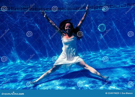 Caucasian Woman Diving In Swimming Pool Wearing White Dressunderwater