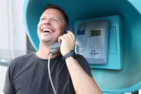 Hombre Joven Sonriente Hablando Por Cabina Telefónica En La Calle