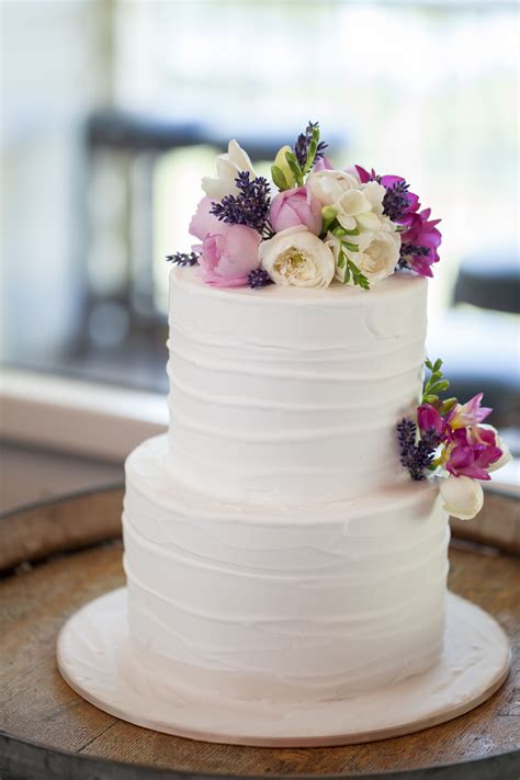 A Classical White Two Tier Wedding Cake Comes To Life With