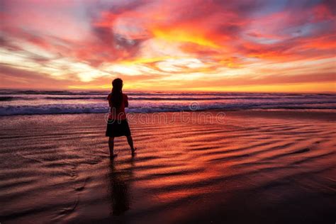 woman walking alone on the beach in the sunset stock image image of outdoors shore 155290271