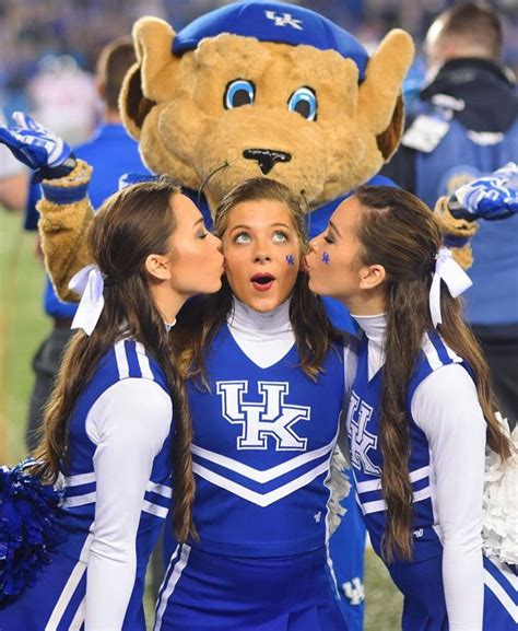 Three Girls In Blue Cheerleader Outfits Kissing Each Other With A Large