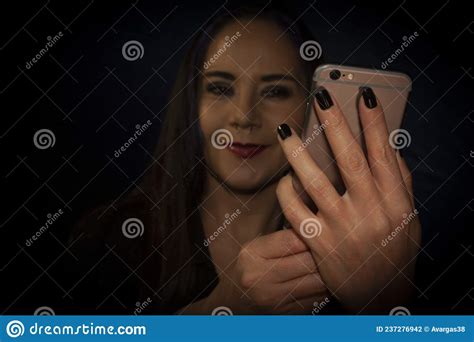 Female Hands Manipulating Mobile Phone To Take Selfie Of Her Face With Bokeh Effect At The End