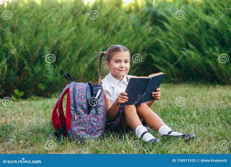 Het Meisje Zit Op Het Gras En Leest Boek Leerlingen Van Lage School Begin Van Lessen Eerste Dag