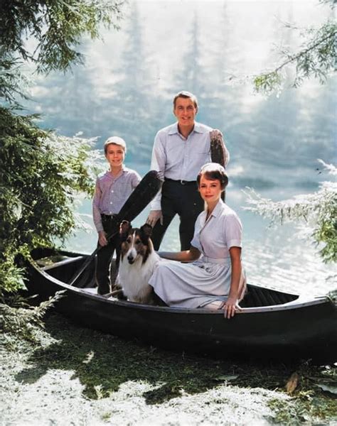 An Old Black And White Photo Of Three People In A Canoe With A Dog