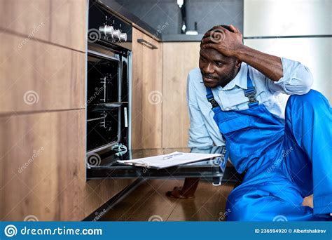 Worried Repairman In Blue Uniform Having Troubles In Work While