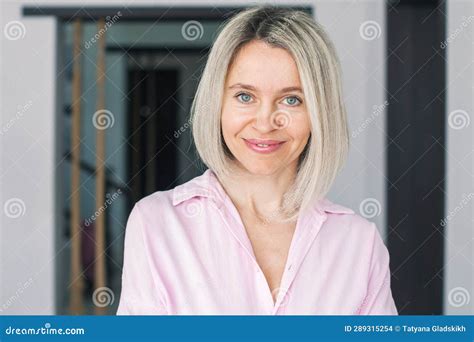 Smiling Middle Aged Mature Woman Looking At Camera At Home Stock Photo
