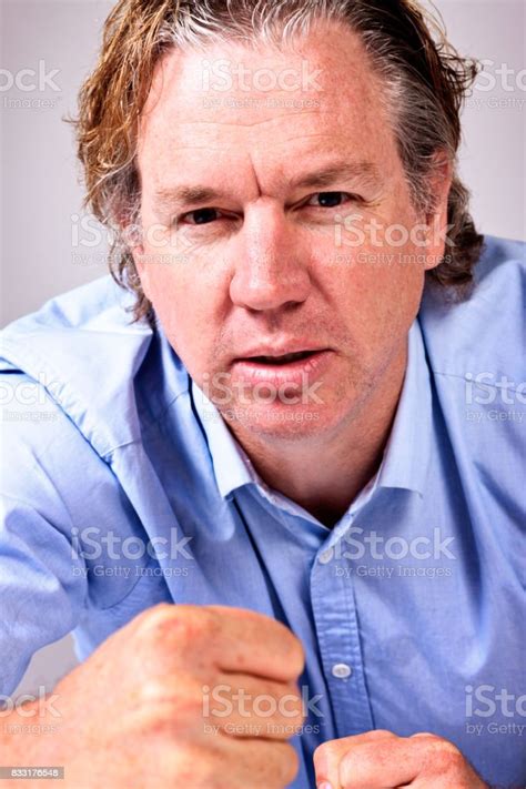 Angry Midadult Man With Clenched Fist Glares At Camera Stock Photo