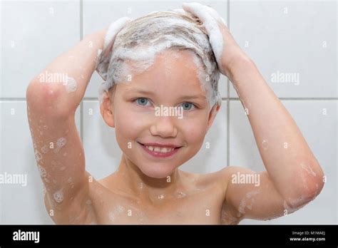 A 9 Year Old Girl Is Standing In The Shower Foaming Her Hair Portrait