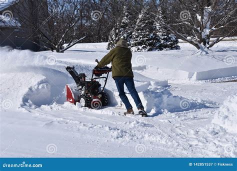 Snowplowing A Driveway And Sidewalk After A Blizzard Stock Image
