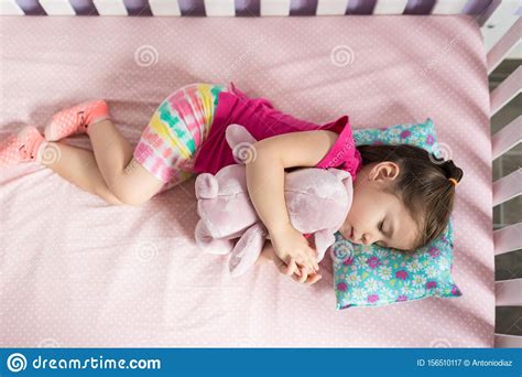 Adorable Toddler Sleeping With Stuffed Toy At Bedroom Stock Image