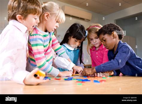 Preschool Children Working Together On Puzzle Stock Photo Alamy