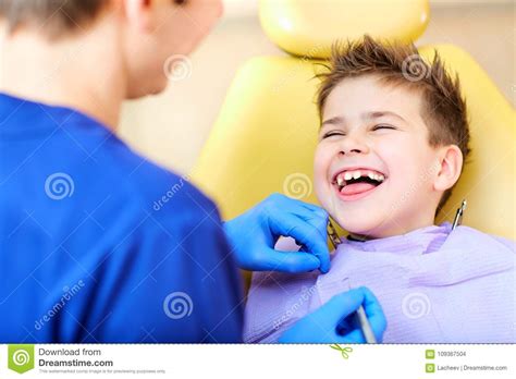 O Dentista Que Verifica Os Dentes Do Adolescente Do Menino Foto De