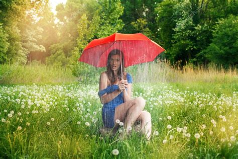 A Girl Caught In A Rain Shower Under Her Umbrella Stock Photo
