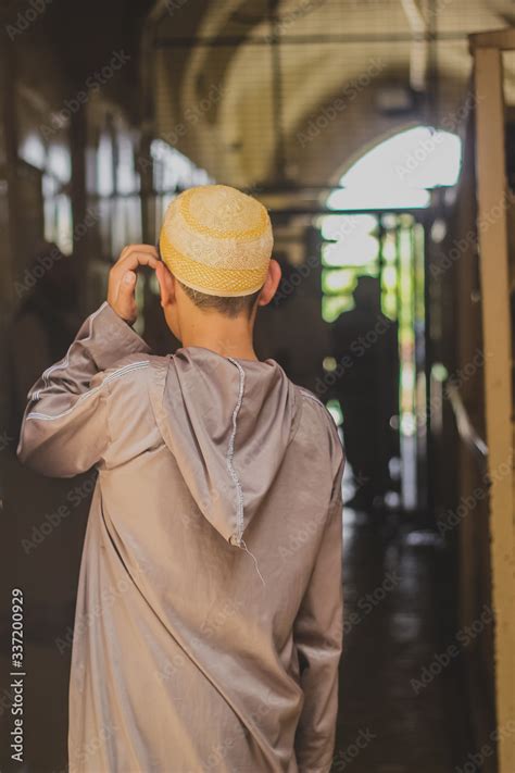 Back View Of Muslim Child Wearing Cap Or Taqiyah On His Way To Mosque
