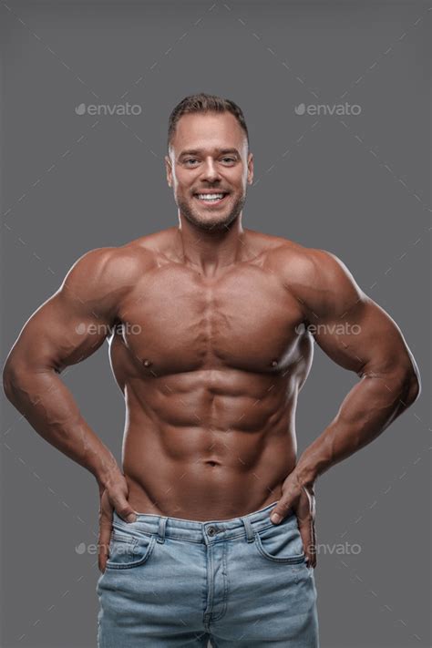 Happy Bodybuilder With Naked Torso Posing Against Gray Background Stock