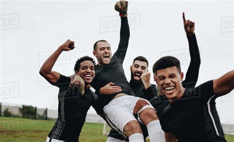 Group Of Happy Soccer Players Celebrating A Win By Lifting Their