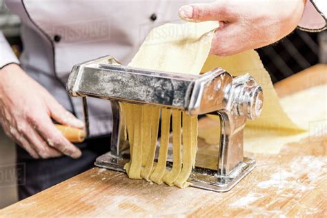 Cropped Image Of Chef Making Pasta With Pasta Maker Stock Photo