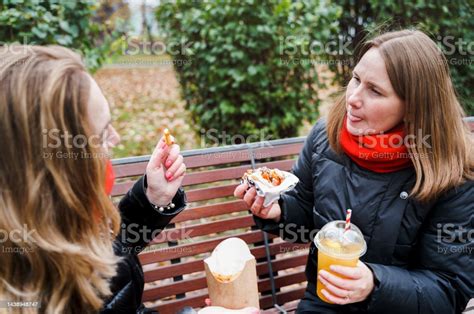 여자 여자 친구 모임 햄버거 먹기 치즈 버거 정크 지방 맛있는 길거리 음식 햄버거를 가져 가라 점심 시간 벤치에 앉아 공원에서