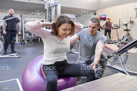 Middleaged Woman Doing Sports Exercise In Fitness Center
