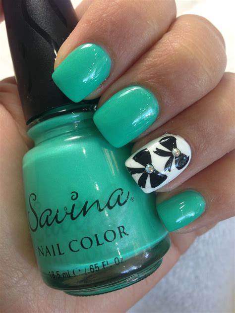 Mint green and white nails with black bow design. Savina Nail Polish