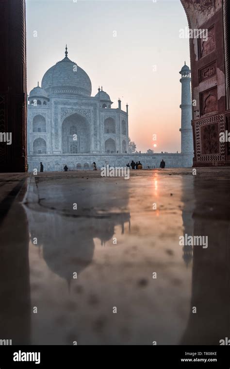 Reflections As The Sun Rises Behind The Taj Mahal Unesco World