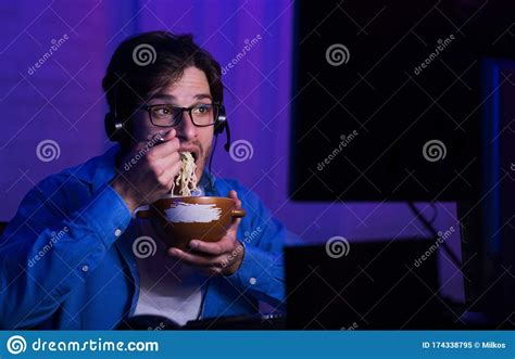 Gamer Eating Noodle Soup Looking At Computer Indoor At Night Stock