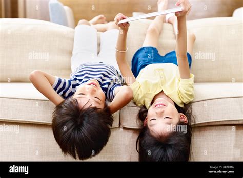 Two Asian Children Little Boy And Little Girl Lying Upside Down On