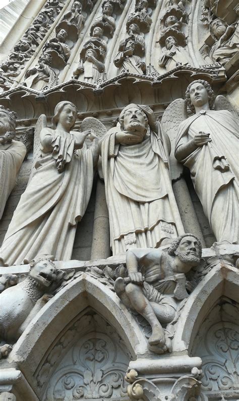 Saint Denis holding his head. Statue at the left portal of Notre Dame 