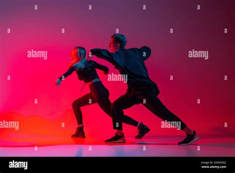 Side View Horizontal Image Of Young Couple Dancing Hip Hop In Stylish Black Clothes Isolated