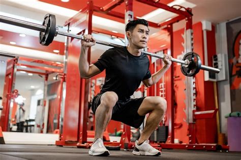 Asian Young Man Using Dumbbell Pushing Up Exercise At Gym For Good