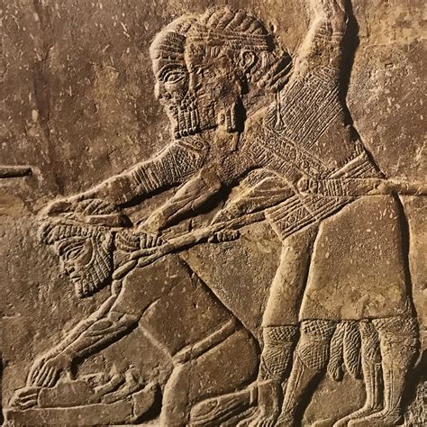 Deux soldats assyriens forçant un captif babylonien à broyer les os de